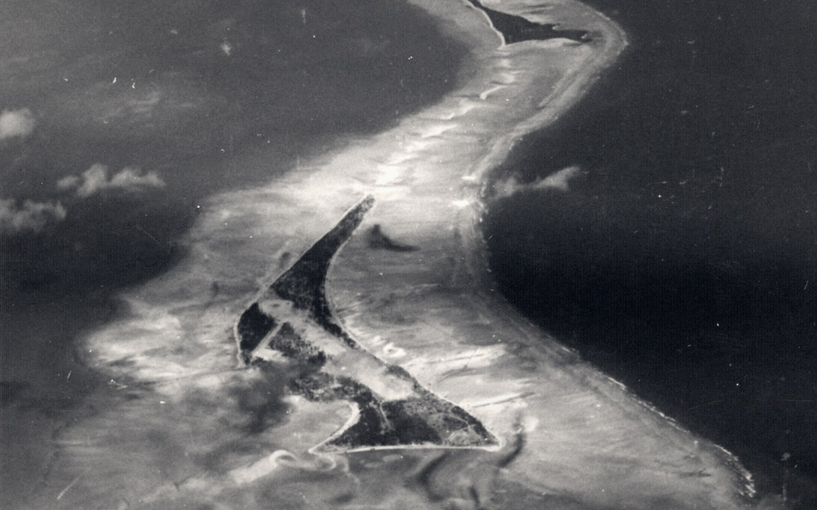 An atoll lagoon photographed from the air: the reef rim, the islets, the open ocean beyond